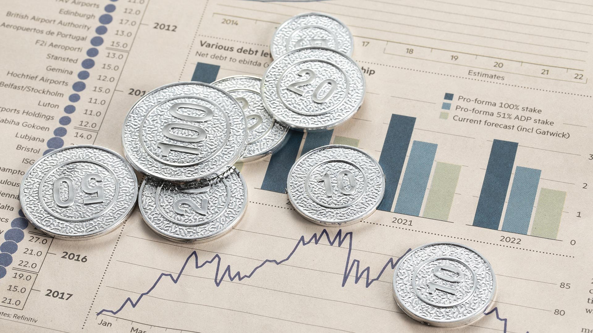 high-angle-shot-silver-coins-pages-with-bar-graphs